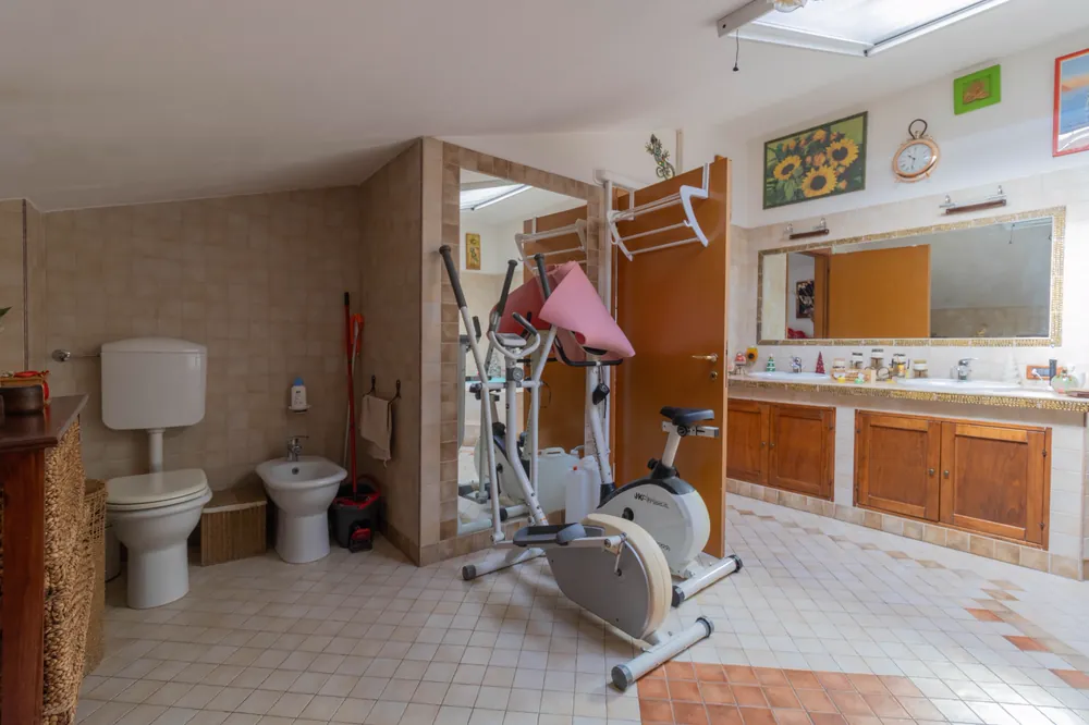 Bagno in mansarda visto dall'ingresso, con lucernario e doppio lavabo