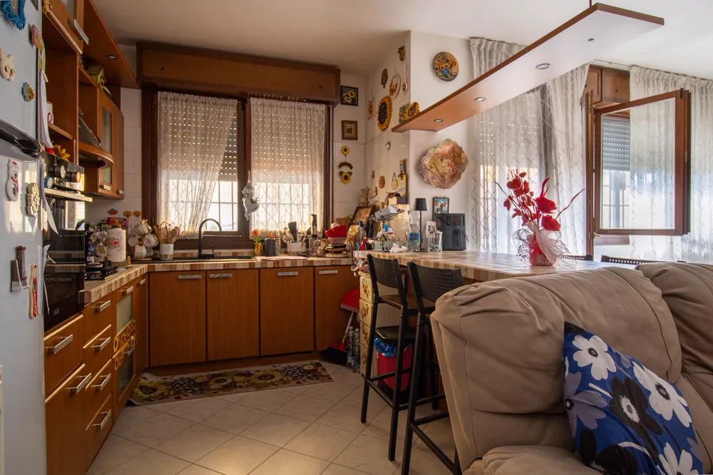 Cucina ad angolo con penisola e finestre sul terrazzo